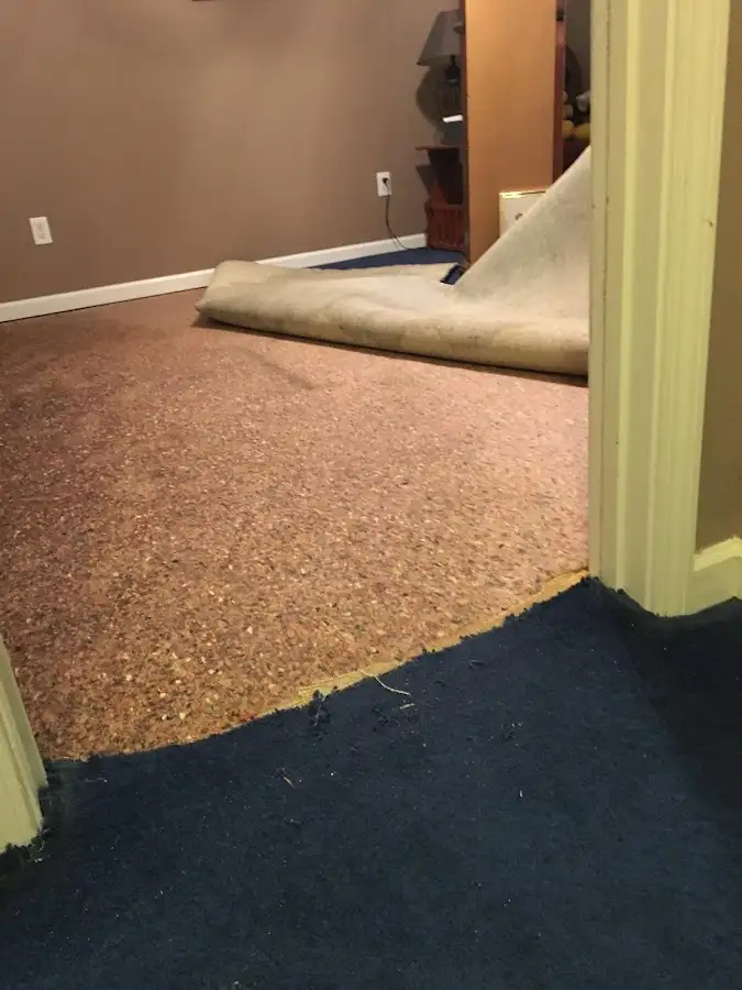 Carpet pad removal revealing water damage during Drying & Dehumidification in Atchison